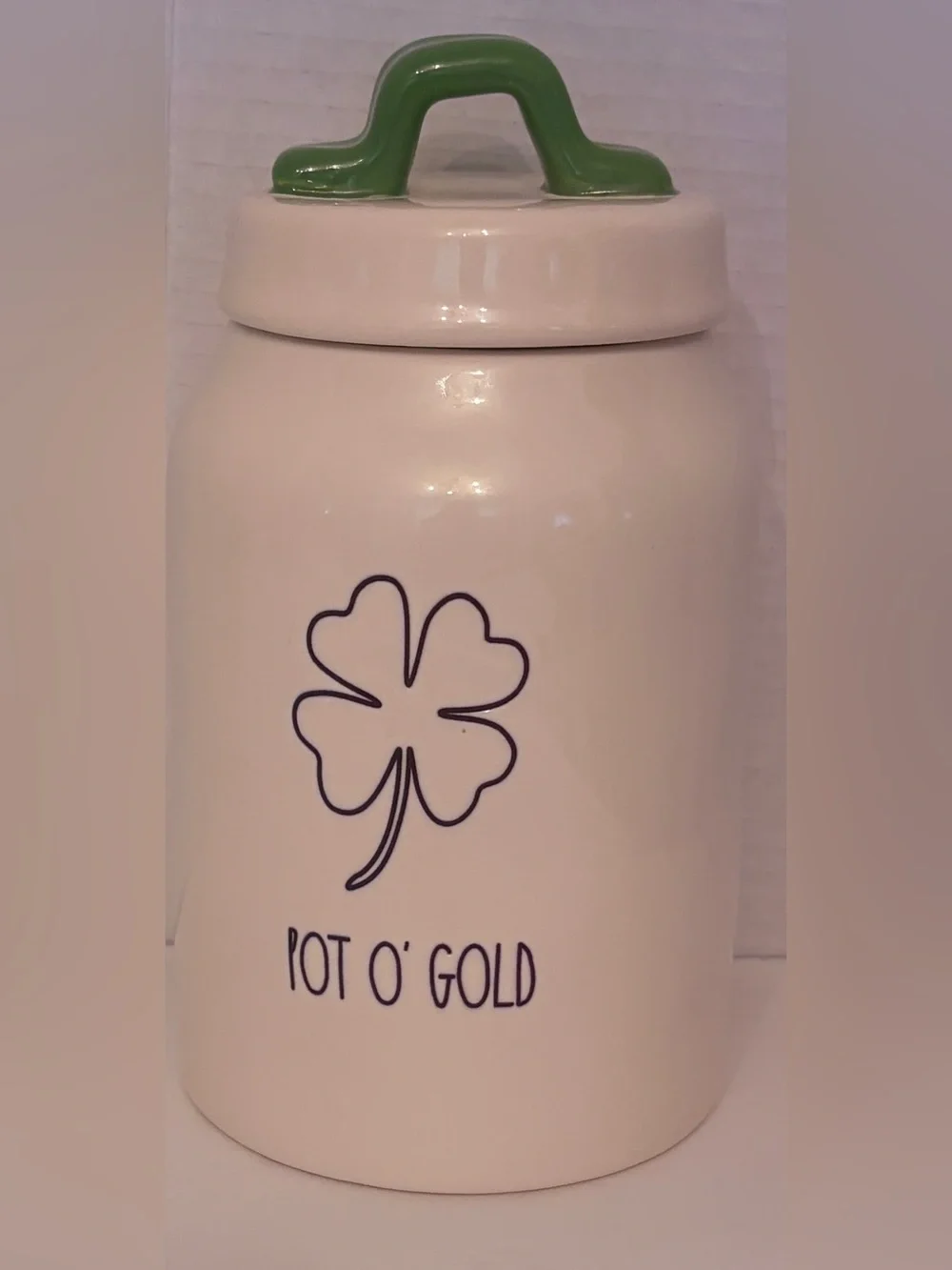 Rae Dunn off White Ceramic 'POT O’GOLD’ Canister with Green Handle covered lid.